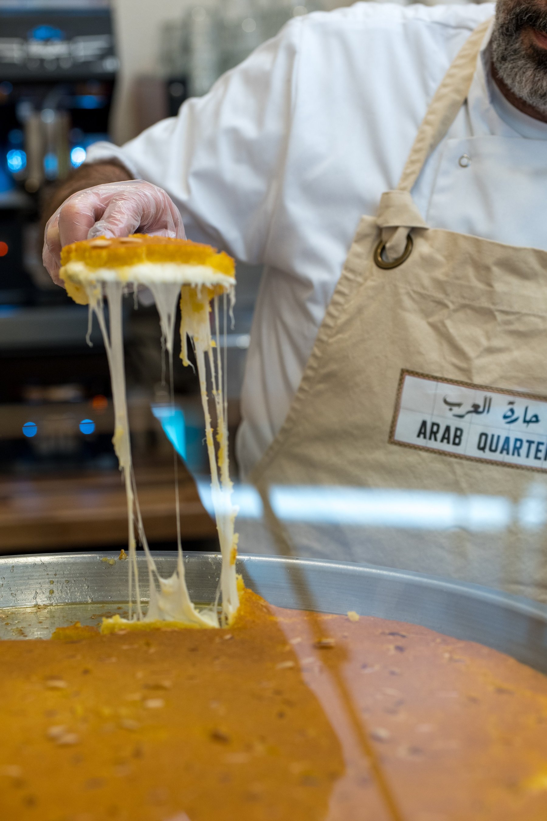 Melted cheese stretching from a slice of kunafa