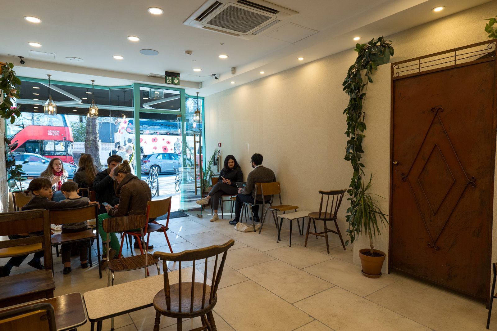 Customers at the tables inside The Arab Quarter, with the red steel door at the back